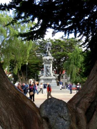 A Punta Arenas Statue thru tree